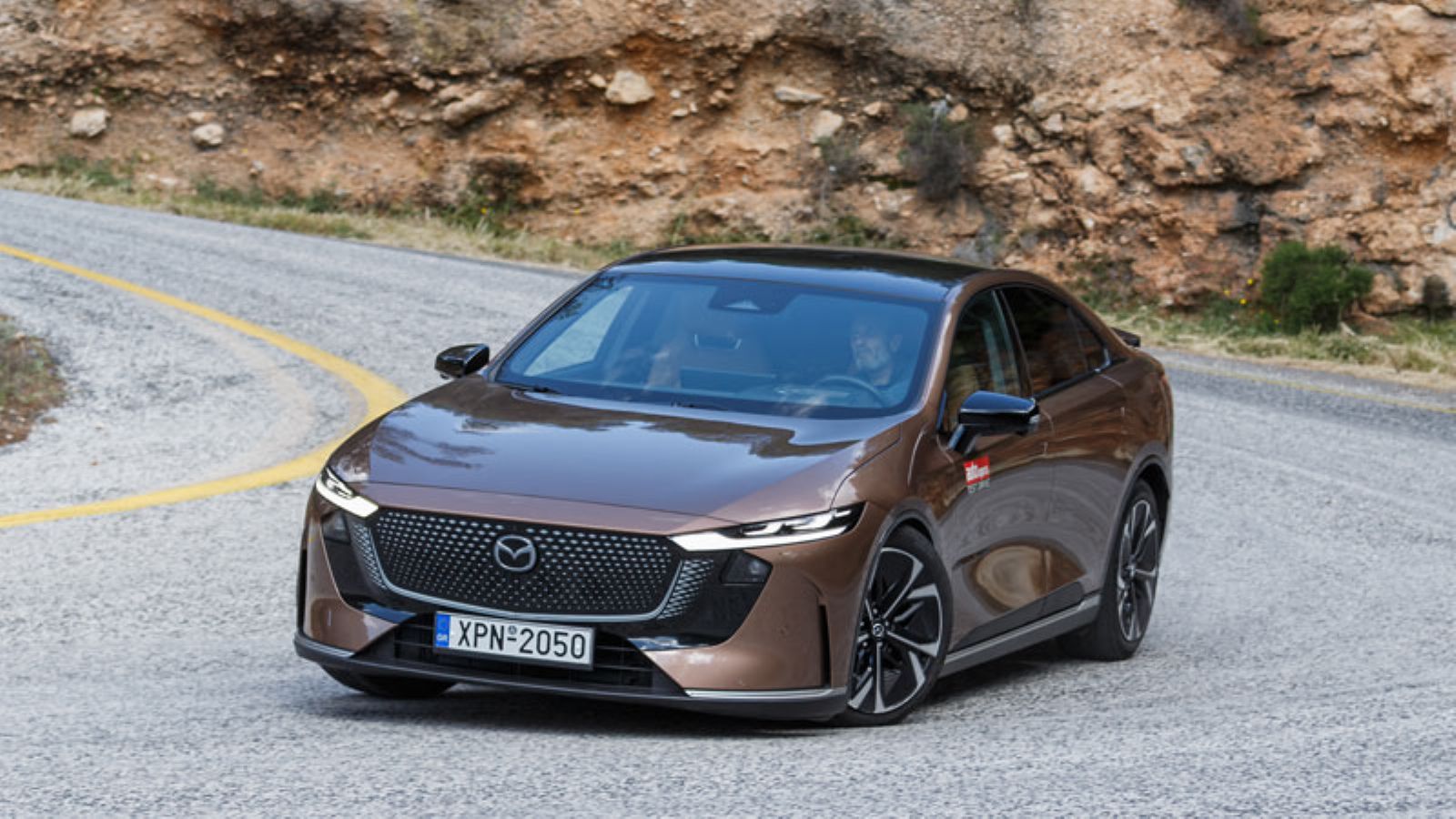 Το Mazda 6e από την εμπρός αριστερή πλευρά, σε στροφή εν κινήσει
