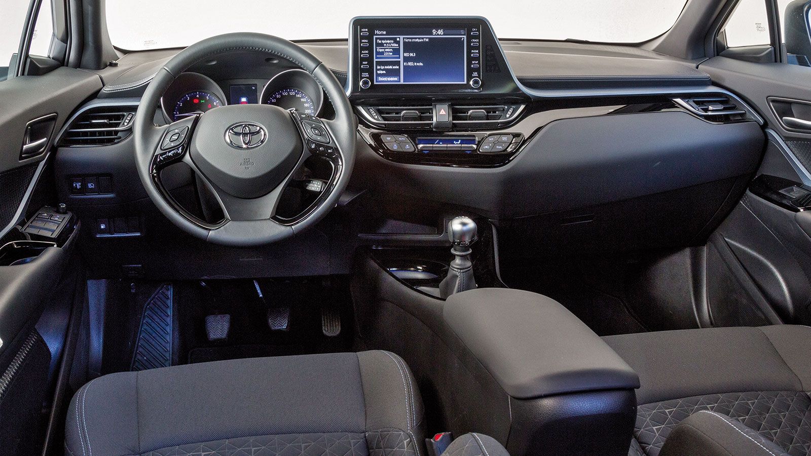 Περνώντας στην καμπίνα του Toyota C-HR, την προσοχή μας τραβά το ασύμμετρο και οδηγοκεντρικό ταμπλό